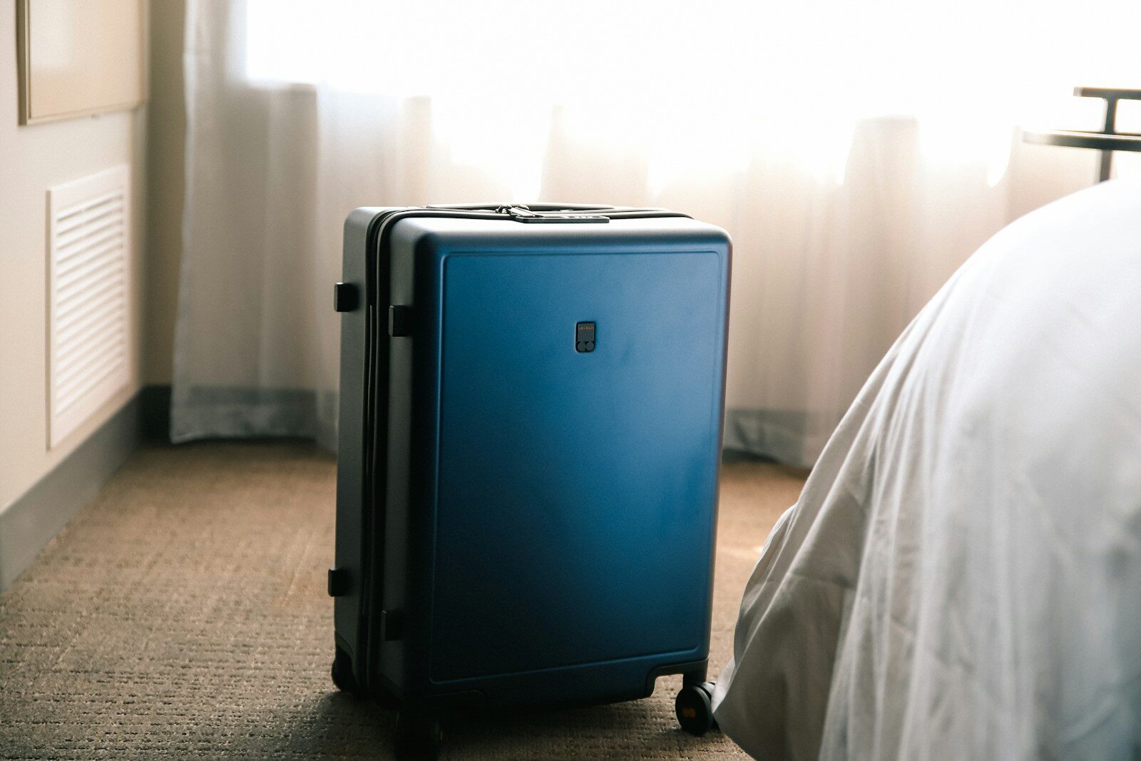 Modern hotel room prepared for guests with travel luggage nearby