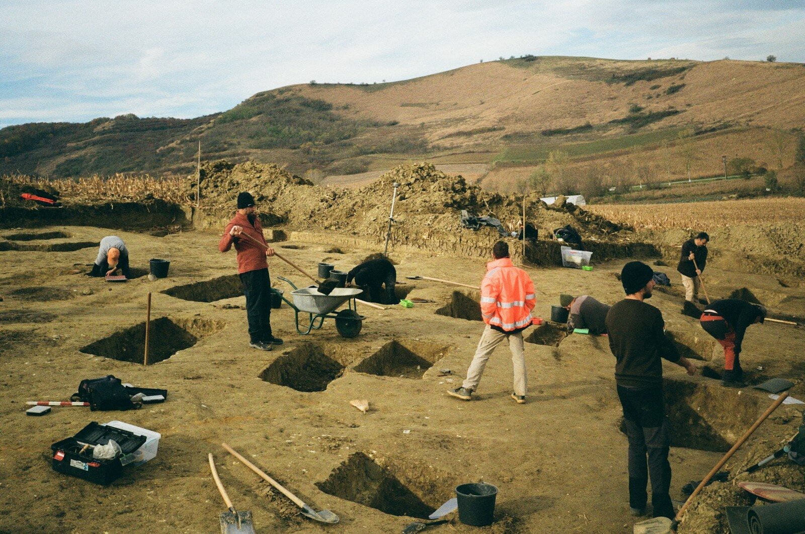 Archaeologists carefully excavating soil at a heritage site